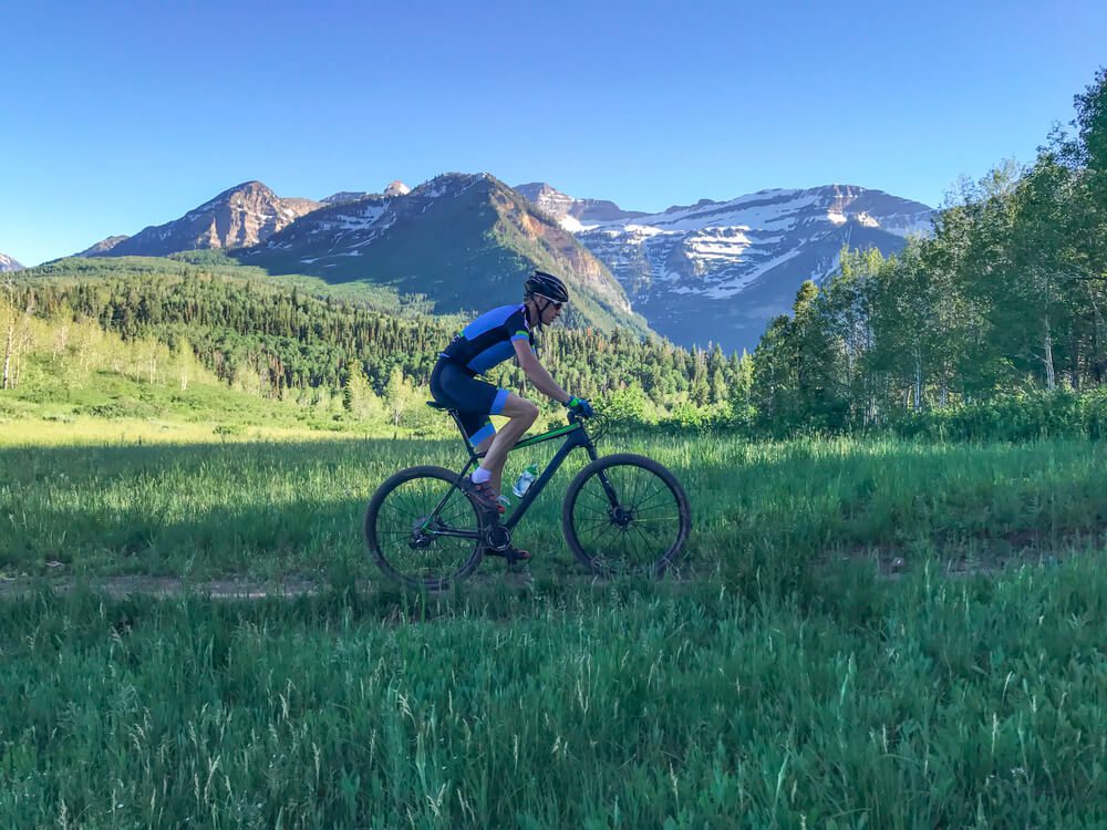 Photo of a person riding a bike next to mountains: utah mountain bike races
